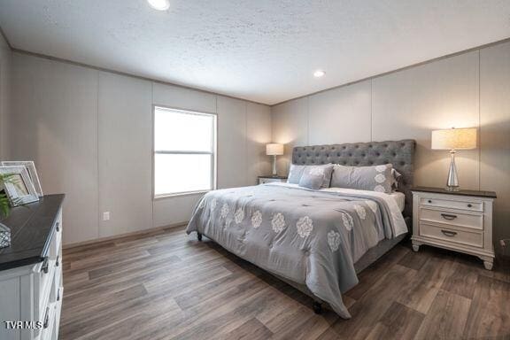 913 Henry Harr Rd, Blountville, TN 37617 - bedroom with a decorative wall, dark wood finished floors, recessed lighting, and a textured ceiling