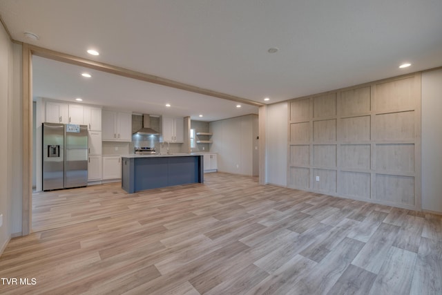 913 Henry Harr Rd, Blountville, TN 37617 - kitchen featuring stainless steel appliances, wall chimney exhaust hood, open floor plan, white cabinetry, and light wood-style floors