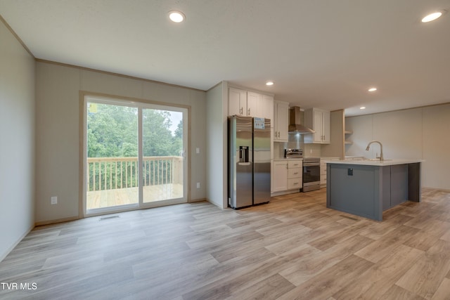 913 Henry Harr Rd, Blountville, TN 37617 - kitchen featuring stainless steel appliances, wall chimney exhaust hood, light countertops, a sink, and light wood finished floors
