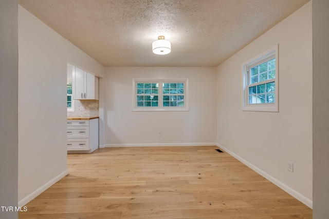 319 Woodland Rd, Jonesborough, TN 37659 - unfurnished dining area featuring a textured ceiling, light wood finished floors, and baseboards