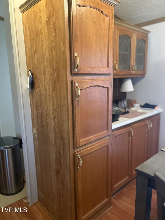 8 Circling Dr, Chuckey, TN 37641 - kitchen with wood finished floors, glass insert cabinets, light countertops, brown cabinetry, and a textured ceiling