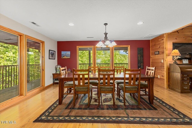 2213 Woodcock Trl, Sevierville, TN 37876 - dining space with a chandelier, wood finished floors, wood walls, recessed lighting, and an accent wall