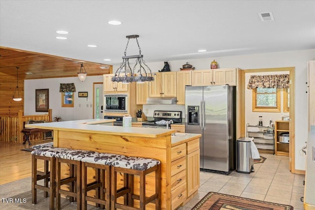 2213 Woodcock Trl, Sevierville, TN 37876 - kitchen with appliances with stainless steel finishes, light brown cabinetry, under cabinet range hood, a center island with sink, and recessed lighting