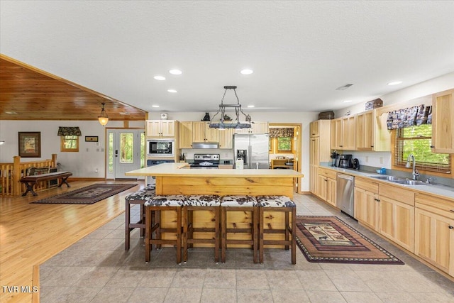 2213 Woodcock Trl, Sevierville, TN 37876 - kitchen featuring stainless steel appliances, light brown cabinets, a sink, healthy amount of natural light, and recessed lighting