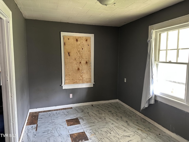 276 Spurgeon Ln, Bristol, VA 24201 - empty room featuring healthy amount of natural light, marble look tile flooring, and baseboards