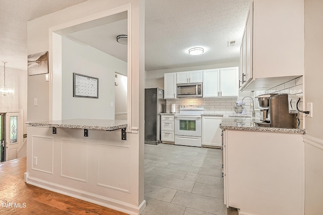 118 Greenmeadow Ln, Jonesborough, TN 37659 - kitchen featuring stainless steel appliances, a sink, white cabinetry, backsplash, and a textured ceiling