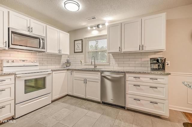 118 Greenmeadow Ln, Jonesborough, TN 37659 - kitchen featuring stainless steel appliances, a sink, backsplash, white cabinetry, and a textured ceiling