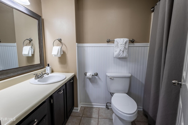 3215 N River Rd Unit 106, Pigeon Forge, TN 37863 - bathroom featuring a wainscoted wall, toilet, vanity, tile patterned flooring, and a shower with shower curtain