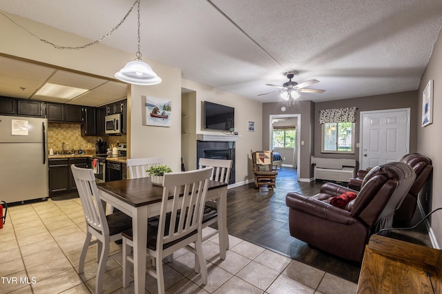 3215 N River Rd Unit 106, Pigeon Forge, TN 37863 - dining room featuring a fireplace, light tile patterned floors, ceiling fan, and baseboards
