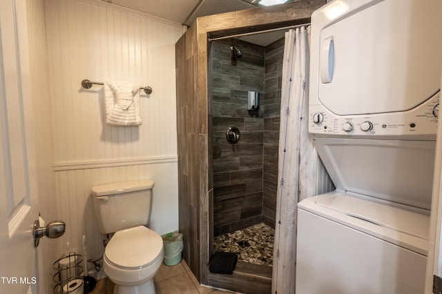 3215 N River Rd Unit 106, Pigeon Forge, TN 37863 - bathroom featuring stacked washer and clothes dryer, a tile shower, tile patterned flooring, and toilet