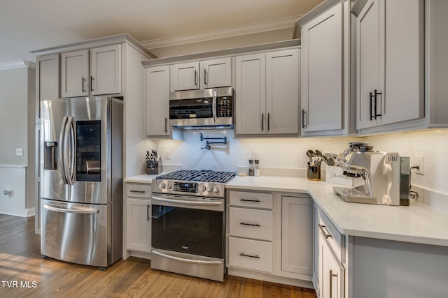 1132 Panoramic Vis, Gray, TN 37615 - kitchen with appliances with stainless steel finishes, ornamental molding, tasteful backsplash, gray cabinetry, and wood finished floors