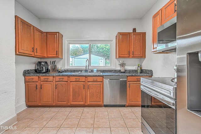 218 W Banner St, Lebanon, VA 24266 - kitchen with appliances with stainless steel finishes, a sink, brown cabinets, dark stone countertops, and light tile patterned flooring