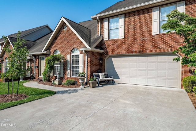 404 E Mountain View Rd Unit 204, Johnson City, TN 37601 - view of front facade with brick siding, concrete driveway, an attached garage, and a shingled roof