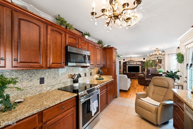 404 E Mountain View Rd Unit 204, Johnson City, TN 37601 - kitchen with appliances with stainless steel finishes, a chandelier, open floor plan, crown molding, and light stone counters
