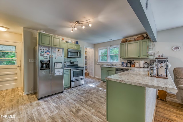 240 Watson Rd, Bristol, TN 37620 - kitchen with green cabinetry, stainless steel appliances, a peninsula, and light wood-style flooring