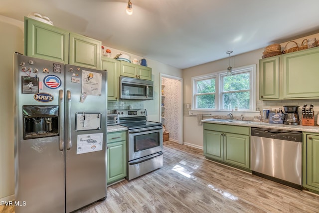 240 Watson Rd, Bristol, TN 37620 - kitchen featuring stainless steel appliances, green cabinets, a sink, tasteful backsplash, and light wood-type flooring