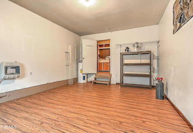 509 9th St, Erwin, TN 37650 - empty room featuring heating unit, wood finished floors, and electric water heater