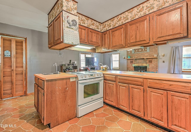 509 9th St, Erwin, TN 37650 - kitchen with electric range, a sink, brown cabinets, and light countertops