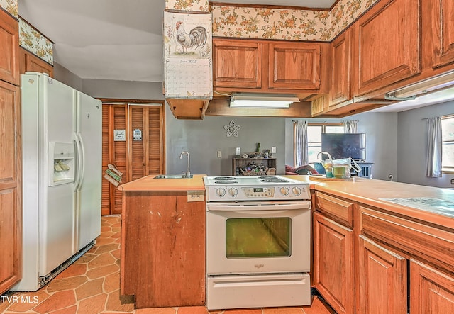 509 9th St, Erwin, TN 37650 - kitchen featuring white appliances, a sink, brown cabinetry, and light tile patterned flooring