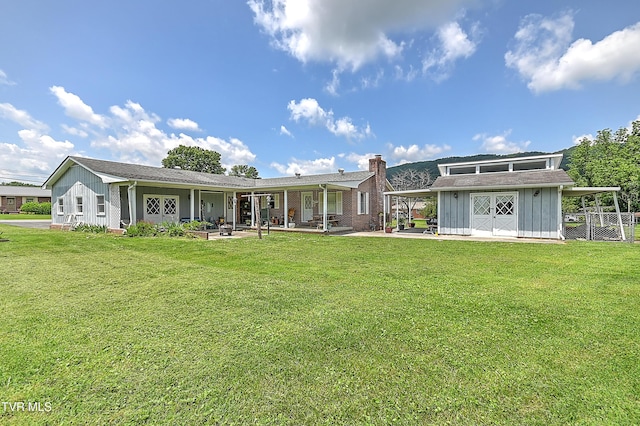 509 9th St, Erwin, TN 37650 - rear view of property featuring board and batten siding, a chimney, an outdoor structure, a patio, and an attached carport
