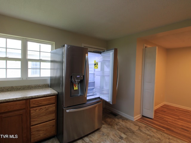 321 W Chilhowie Ave, Johnson City, TN 37604 - kitchen with stainless steel refrigerator with ice dispenser, brown cabinetry, dark countertops, and baseboards