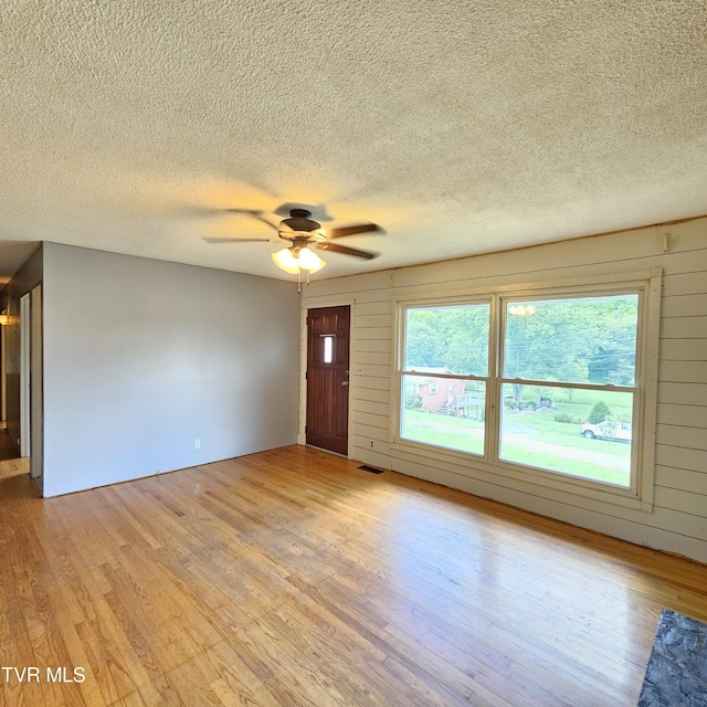 515 Chuckey Pike, Chuckey, TN 37641 - empty room with light wood-style floors, healthy amount of natural light, a textured ceiling, and a ceiling fan