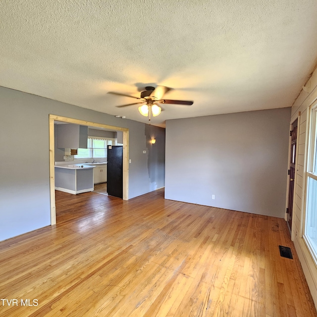 515 Chuckey Pike, Chuckey, TN 37641 - unfurnished living room with light wood-style floors, a ceiling fan, and a textured ceiling