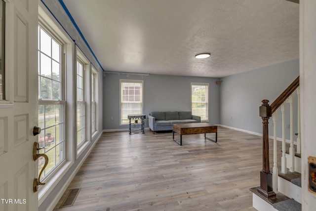 23270 Denton Valley Rd, Abingdon, VA 24211 - living room featuring light wood-style flooring, stairs, baseboards, and a textured ceiling