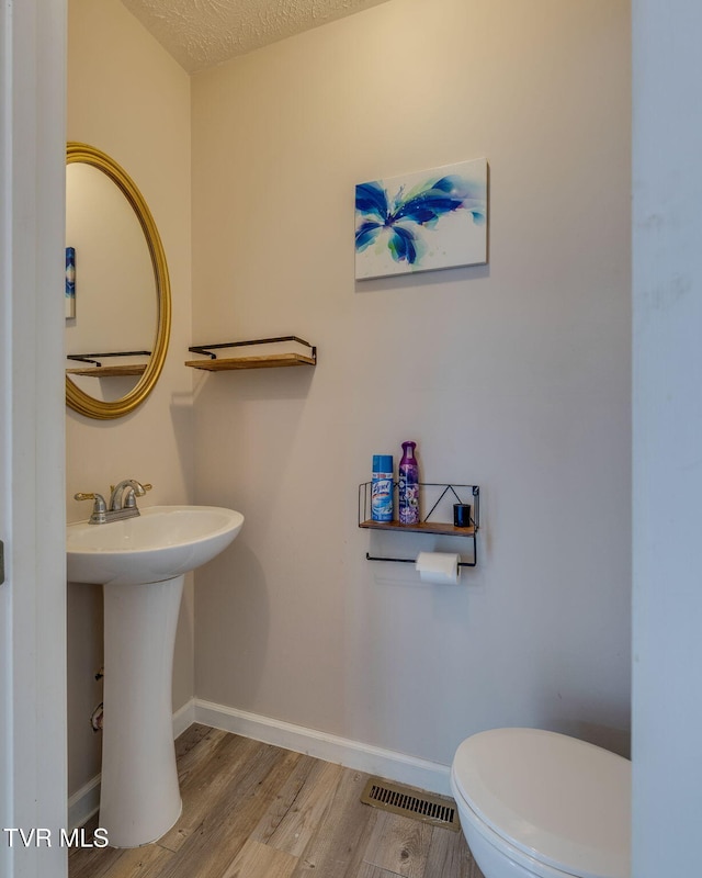 23270 Denton Valley Rd, Abingdon, VA 24211 - half bathroom with toilet, wood finished floors, baseboards, a sink, and a textured ceiling