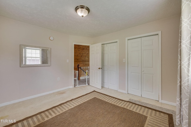 23270 Denton Valley Rd, Abingdon, VA 24211 - unfurnished bedroom featuring multiple closets, baseboards, a textured ceiling, and light carpet