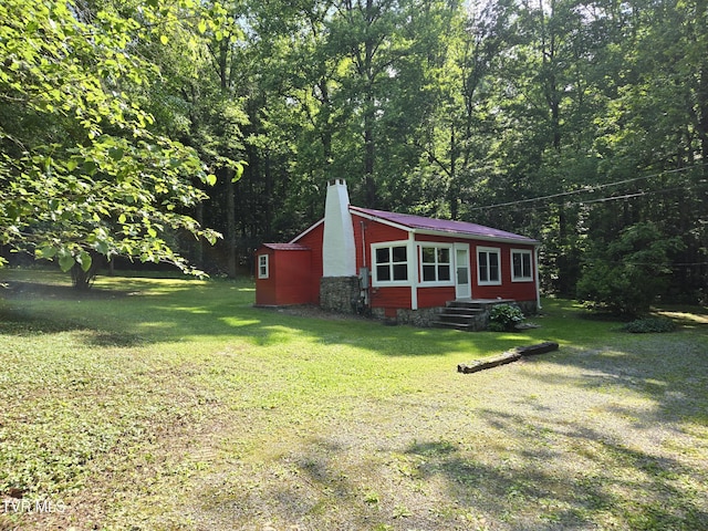 1510 Rock Creek Rd, Erwin, TN 37650 - view of front of home with a chimney, a front yard, a wooded view, and an outbuilding