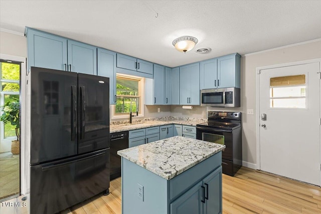 1820 Brook Hollow Rd, Johnson City, TN 37604 - kitchen with black appliances, blue cabinetry, light wood finished floors, ornamental molding, and light stone counters