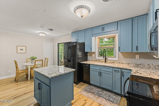 1820 Brook Hollow Rd, Johnson City, TN 37604 - kitchen with black appliances, a sink, blue cabinets, light wood-style flooring, and a kitchen island