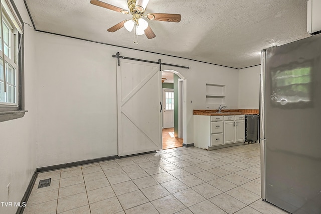 125 Cedar Valley Rd, Bristol, TN 37620 - spare room featuring arched walkways, ceiling fan, a barn door, a textured ceiling, and a sink