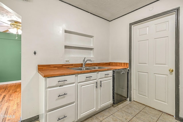 125 Cedar Valley Rd, Bristol, TN 37620 - kitchen with dishwashing machine, butcher block counters, a sink, white cabinetry, and a textured ceiling