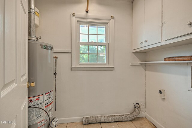 125 Cedar Valley Rd, Bristol, TN 37620 - laundry area with gas water heater, cabinet space, baseboards, and light tile patterned flooring