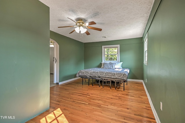125 Cedar Valley Rd, Bristol, TN 37620 - bedroom featuring wood finished floors, a textured ceiling, baseboards, arched walkways, and ceiling fan