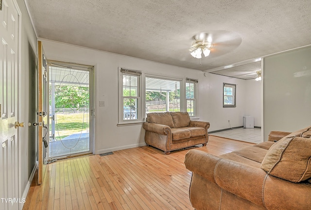 125 Cedar Valley Rd, Bristol, TN 37620 - living room featuring a textured ceiling, light wood-style flooring, ceiling fan, and baseboards