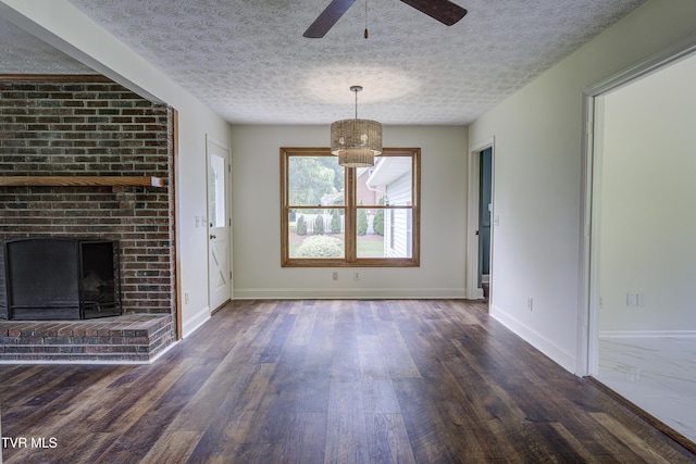 715 Powder Branch Rd, Elizabethton, TN 37643 - unfurnished living room featuring dark wood-type flooring, a brick fireplace, baseboards, a ceiling fan, and a textured ceiling