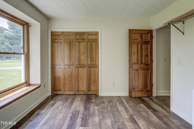 715 Powder Branch Rd, Elizabethton, TN 37643 - unfurnished bedroom with dark wood-style flooring, multiple windows, a textured ceiling, and baseboards