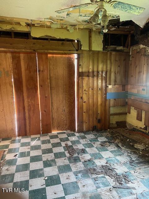 534 Ohio Ave, Erwin, TN 37650 - empty room featuring tile patterned floors, wood walls, and ceiling fan