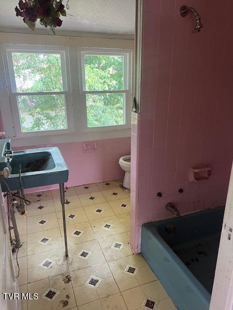 534 Ohio Ave, Erwin, TN 37650 - full bathroom featuring tile patterned floors, toilet, tile walls, a sink, and shower / bathtub combination
