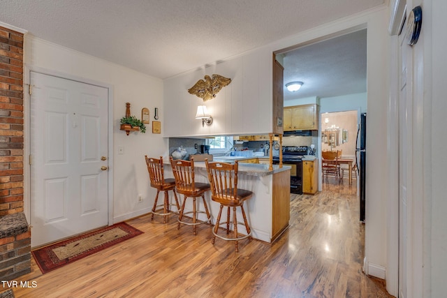 396 High Cir, Bristol, TN 37620 - kitchen featuring black appliances, light wood-style floors, a textured ceiling, a peninsula, and crown molding