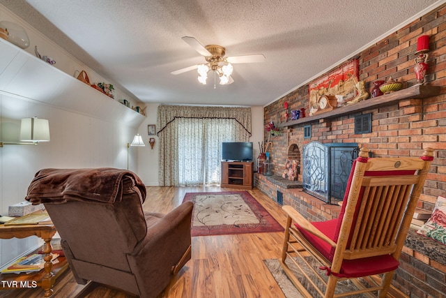 396 High Cir, Bristol, TN 37620 - living area featuring wood finished floors, a textured ceiling, a ceiling fan, a brick fireplace, and brick wall