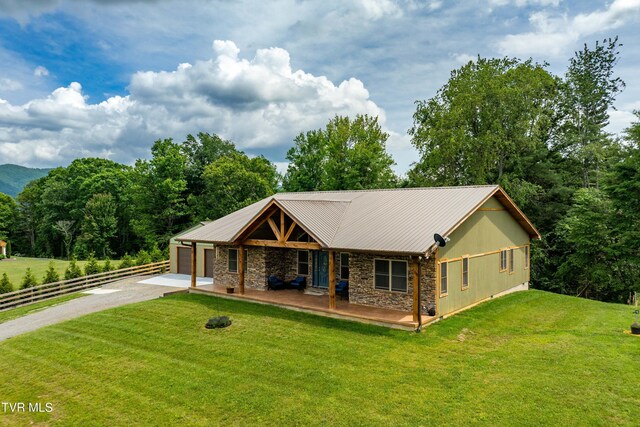 271 Laurel Way, Mountain City, TN 37683 - view of front of house featuring stone siding, driveway, an attached garage, metal roof, and covered porch