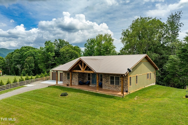 271 Laurel Way, Mountain City, TN 37683 - view of front facade featuring stone siding, driveway, an attached garage, metal roof, and covered porch