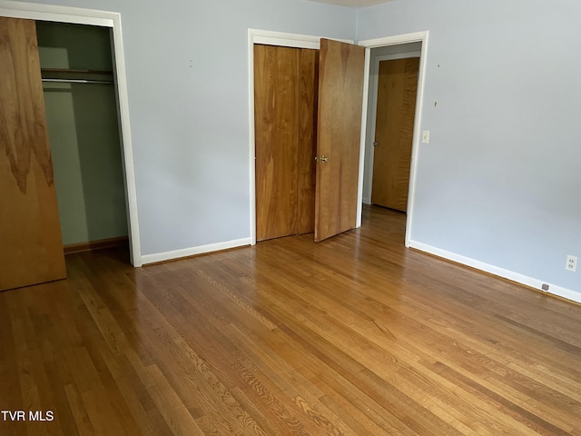 201 Brown St, Appalachia, VA 24216 - unfurnished bedroom featuring two closets, baseboards, and wood finished floors