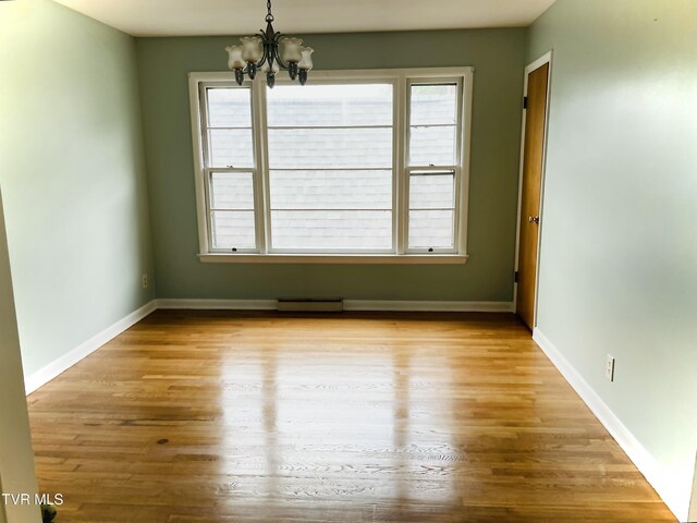 201 Brown St, Appalachia, VA 24216 - empty room featuring a chandelier, wood finished floors, and baseboards