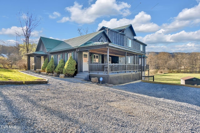 136 Beecher Holtsclaw Rd, Roan Mountain, TN 37687 - view of front facade featuring a porch, metal roof, and driveway