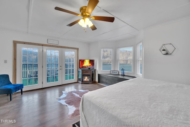 136 Beecher Holtsclaw Rd, Roan Mountain, TN 37687 - bedroom with access to outside, wood finished floors, a warm lit fireplace, french doors, and a ceiling fan